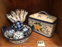 View showing Delft Blauw bowl with basket handles, decorative balls inside, and lemon decorated lidded box