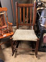 Full-sized wooden rocking chair with woven seat and slatted back, measuring approximately 16x26x33 inches.