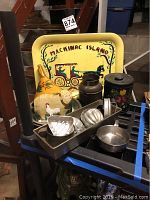 Photo of vintage tin Mackinac Island tray, assorted folk art and kitchen items arranged on a shelf.