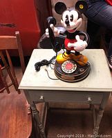 Vintage Telemania Mickey Mouse rotary dial phone with handset on table