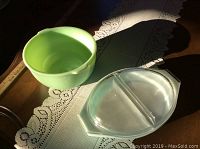 Photo of vintage green glass bowl and two-section clear glass dish placed on a lace table runner.