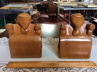 Front view of both hand carved wooden turtle bookends on table showing symmetrical design and wood grain.