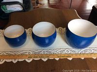 Three Dansk blue enamel mixing bowls lined up from smallest to largest, showing size and color