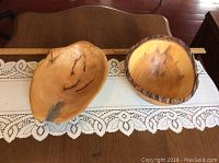 Two wooden bowls placed side by side showing size and shape difference, one with live bark edge, the other smooth maple bowl