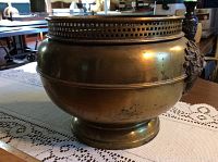 Side angle showing the brass jardiniere and decorative flower basket applique on the side with signs of wear and old repair.