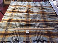 Full view of wool blanket spread flat with a measuring stick showing size of 58x58 inches.