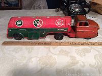 Side view of the vintage pressed steel BA fuel tanker truck toy with visible logos and paint wear.
