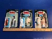 Three Star Wars Empire Strikes Back action figures of Princess Leia in original Kenner packages with a ruler beneath for scale.