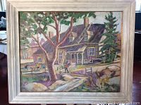 Full view of the oil painting showing the house, trees and figures within a wooden frame.