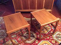 Two identical teak end tables side by side on patterned rug