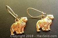 Pair of small 10K gold bear charm earrings on shepherd hook wires, showing detail and condition of fronts.