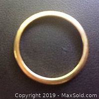 Close-up image of the circular 10K gold band ring showing smooth polished surface.