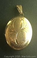 Front view of closed oval locket showing etched floral design