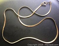 Gold chain on black background showing entire chain and spring ring clasp