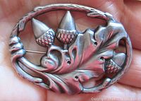 Front of the oval Danecraft sterling silver brooch showing three acorns and oak leaves in open work design.