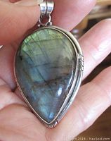 Front close-up view of the large pear-shaped labradorite stone pendant showing multicolored flashes and silver setting.