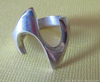 Close-up side view of vintage modernist sterling silver ring with smooth curved design and polished finish, no visible damage.