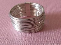 Front angled view of the 12 tiny band sterling silver ring showing all bands and the connector piece holding them together.