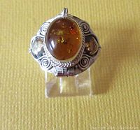 Front view of the vintage sterling silver ring showing amber cabochon and filigree design.