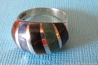 Image showing front view of curved sterling silver ring with black onyx, green onyx, tiger's eye, sodalite, and jasper inlays alternating with silver.