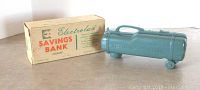 Photo showing the green Electrolux vacuum cleaner coin bank alongside its original box with branding and product details.