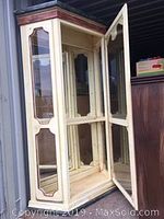 Open door view showing interior with four glass shelves for display.