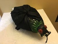 Front and side views of the Halloween jumping bug decoration showing the green textured bug head with red eyes and black wrapped fabric wings.