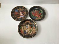 Three Bradford Exchange decorative collector plates shown together, featuring colorful Russian-themed painted scenes with ornate borders.