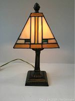 Full view of 14-inch Tiffany style table lamp illuminated showing stained glass pattern and metal base.