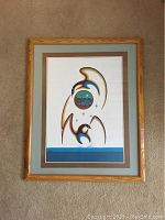 Full view of framed Indigenous print artwork showing two stylized birds and circular landscape in muted colors.