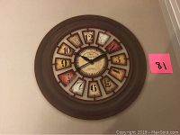Photo of 29 inch round wall clock showing detailed colorful number plaques and oil rubbed bronze frame, black hour and minute hands
