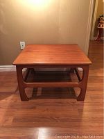 Front and angled view of wooden mid century square coffee table showing top and leg design.