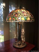 Full view of Tiffany-style table lamp on wooden surface