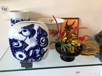 Group of vintage vases and copper deer plaque displayed on a glass shelf.