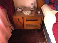 Two matching mid century modern bedside tables with glass tops, placed beside beds on carpeted floor.