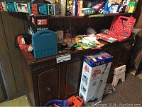 Full view of tools and supplies arranged on cabinet and shelves showing Mop Vac box, Makita case, air compressor, gloves, painting supplies