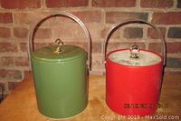 Front view of two vintage plastic ice buckets, red and green, showing lids with knobs and clear plastic handles.