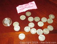 Photo showing 19 Mercury dimes arranged on a wooden surface with a handwritten paper label.