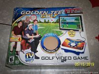 Front of Golden Tee Golf game box featuring four players using the controller, branding, and gameplay imagery.