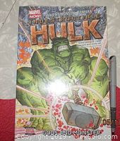 Front cover of the Indestructible Hulk: Gods and Monster Vol. 2 hardcover showing the Hulk holding Thor's hammer with lightning and fire background.