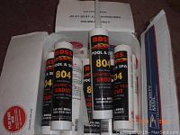 Photo showing multiple BOSS 804 Ceramic Tile Grout tubes stacked in a USPS box.