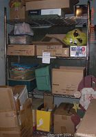 Metal shelving unit assembled with various boxes and items on the shelves, showing size and condition.