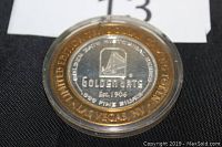 Top view of the round limited edition coin with detailed Golden Gate Casino emblem, text and hallmark visible under plastic case.