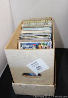 Cardboard box labeled 'Star Trek' filled with assorted comic books in plastic sleeves viewed from top