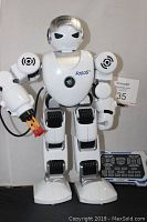 Full body image of the FoBOS remote control robot showing front view with dart throwing arm and remote control in background.