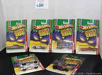 Six Hot Wheels Mardi Gras 2010 cars in original packaging displayed, front view showing colorful Mardi Gras artwork.