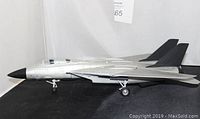 Side view showing detailed die cast model jet plane with landing gear and black nose cone.