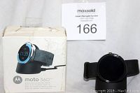 Moto 360 watch displayed next to its branded box, showing front side of watch and box graphics.