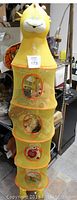 Front view of tall yellow giraffe head mesh storage unit showcasing head and four circular mesh compartments