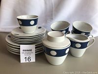 Set of 5 cups and saucers, 5 plates, creamer and sugar bowl displayed with a maxsold lot number card